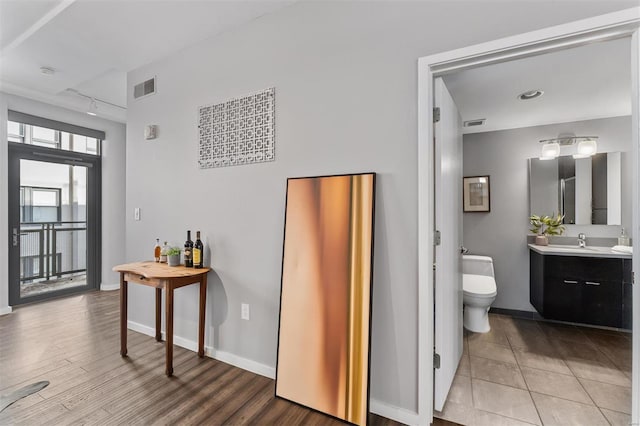 bathroom featuring vanity, hardwood / wood-style floors, track lighting, and toilet