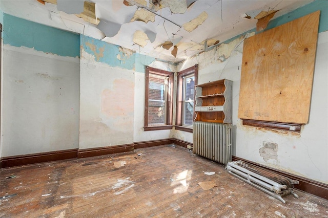 spare room featuring hardwood / wood-style floors and radiator heating unit