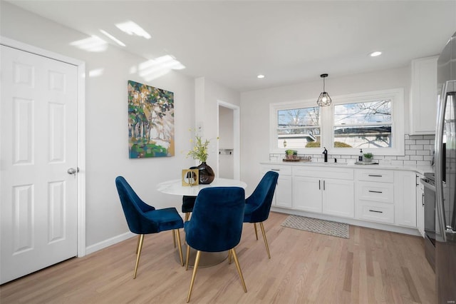 dining room with sink and light hardwood / wood-style flooring