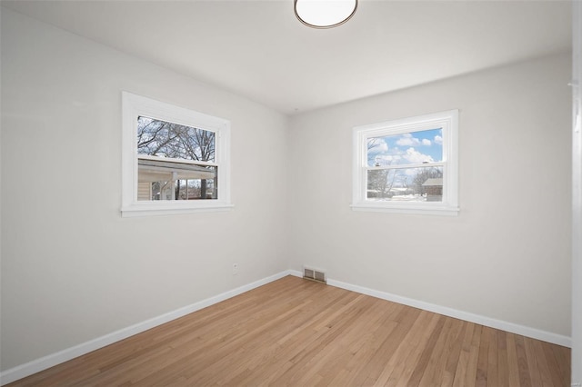 unfurnished room featuring plenty of natural light and light hardwood / wood-style floors