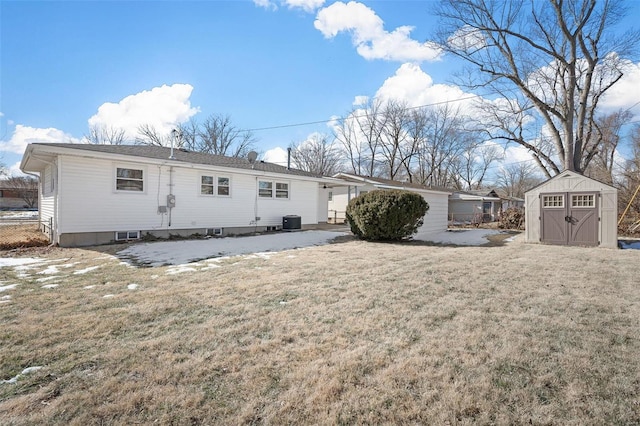 rear view of house featuring central AC, a storage shed, and a yard