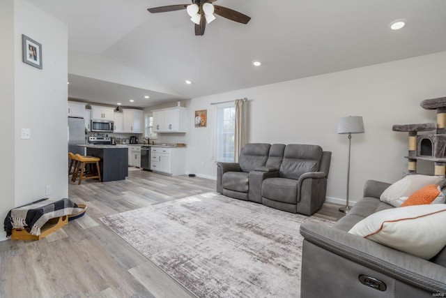 living room with vaulted ceiling, sink, ceiling fan, and light hardwood / wood-style floors