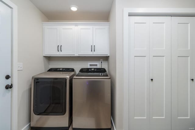 laundry area with separate washer and dryer and cabinets