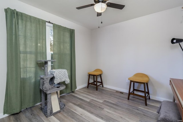 living area with hardwood / wood-style flooring and ceiling fan