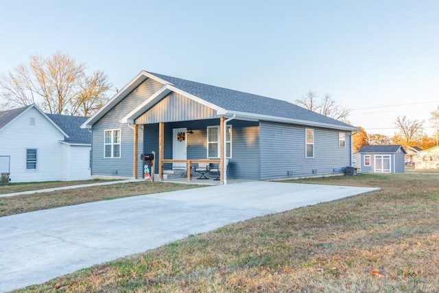 ranch-style house with a porch, a storage shed, and a front lawn