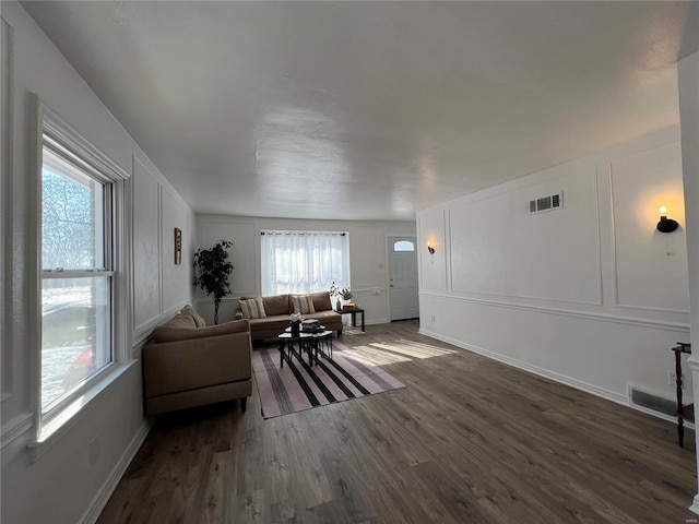 living room featuring plenty of natural light and dark hardwood / wood-style floors