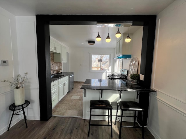 kitchen with stainless steel appliances, a breakfast bar area, and white cabinets