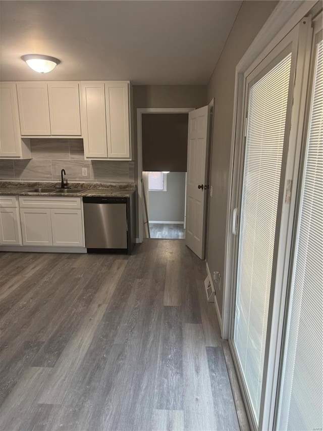 kitchen featuring dark hardwood / wood-style floors, tasteful backsplash, dishwasher, sink, and white cabinets