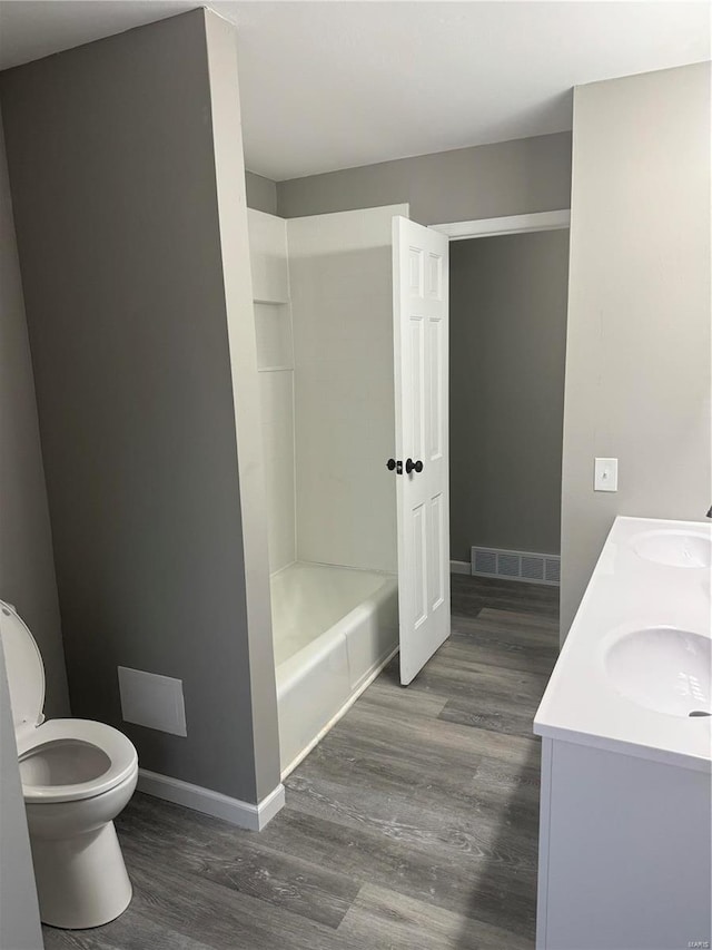 bathroom featuring wood-type flooring, toilet, and vanity