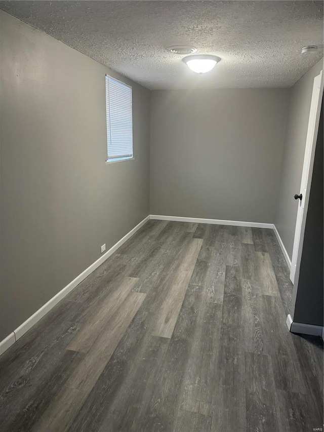 empty room featuring dark hardwood / wood-style floors and a textured ceiling