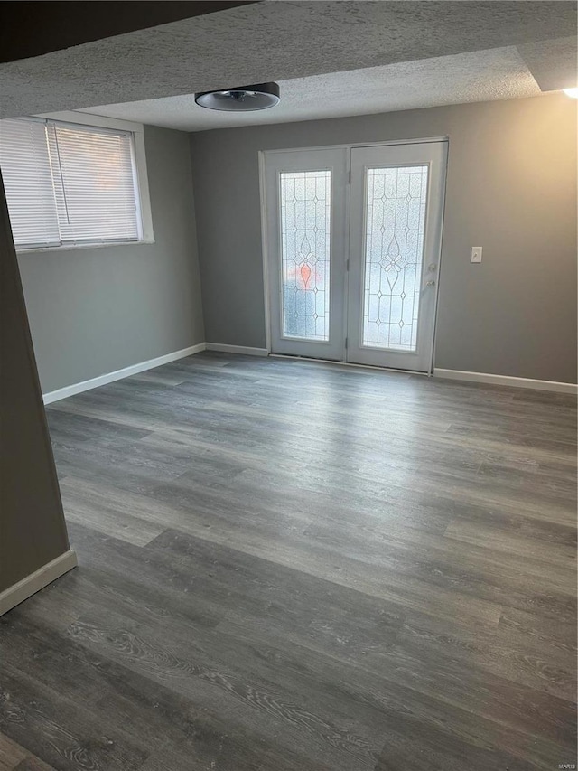 spare room featuring dark hardwood / wood-style flooring and a textured ceiling