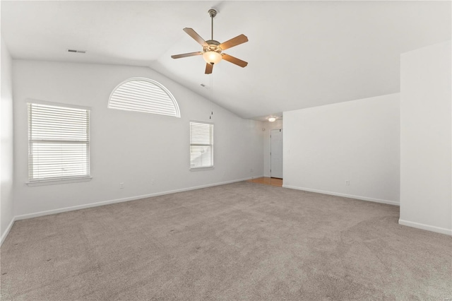 unfurnished room with ceiling fan, light colored carpet, and vaulted ceiling