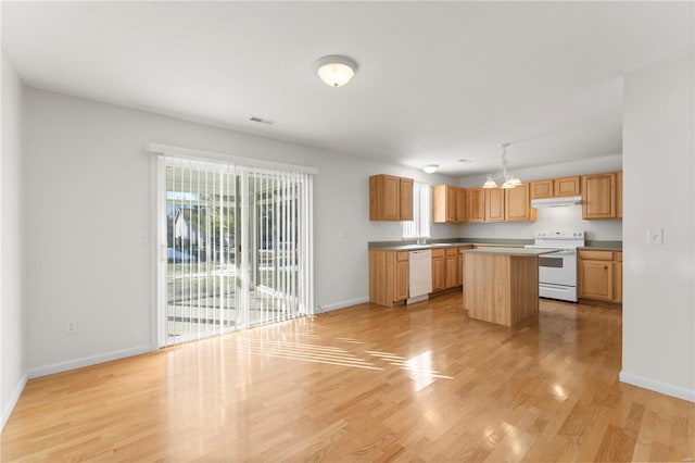 kitchen featuring sink, white appliances, light hardwood / wood-style flooring, a kitchen island, and decorative light fixtures