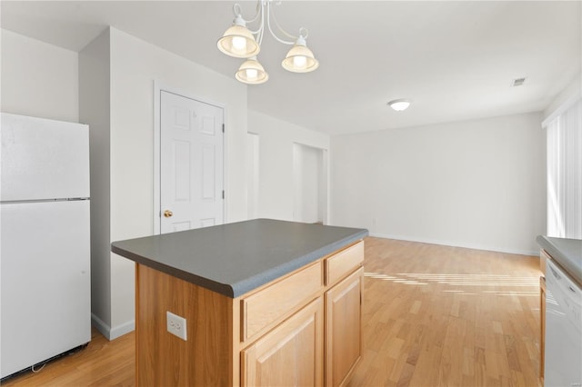 kitchen with an inviting chandelier, decorative light fixtures, a kitchen island, white appliances, and light hardwood / wood-style floors