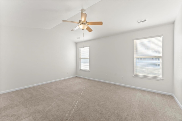 carpeted spare room featuring ceiling fan and vaulted ceiling