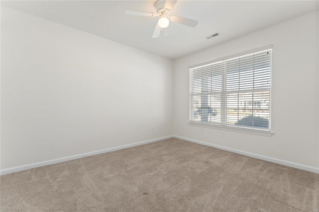 spare room with ceiling fan and light carpet