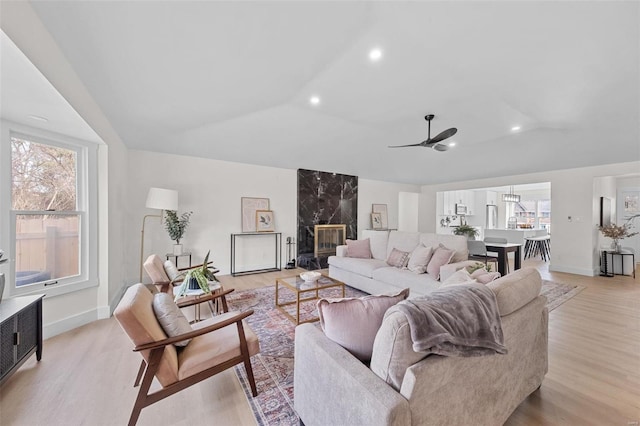 living room featuring lofted ceiling, a wealth of natural light, light hardwood / wood-style floors, and ceiling fan