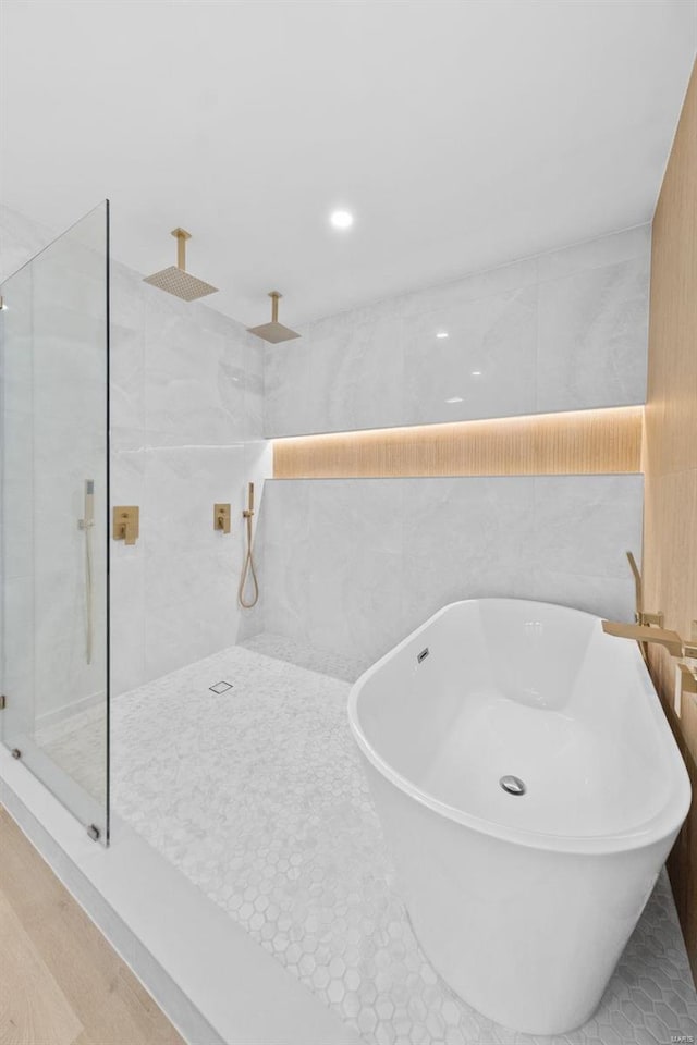 bathroom featuring tiled shower and tile walls