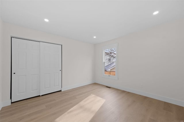 unfurnished bedroom featuring a closet and light wood-type flooring