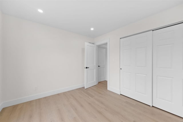 unfurnished bedroom featuring a closet and light wood-type flooring