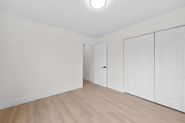 unfurnished bedroom featuring light hardwood / wood-style floors and a closet