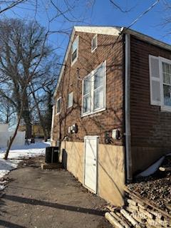 snow covered property featuring central AC unit