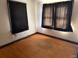 unfurnished room featuring hardwood / wood-style floors and ornamental molding