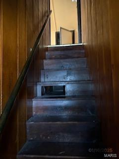 stairs featuring a barn door and wooden walls