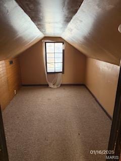 additional living space featuring lofted ceiling and light colored carpet