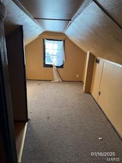 bonus room with lofted ceiling and light carpet