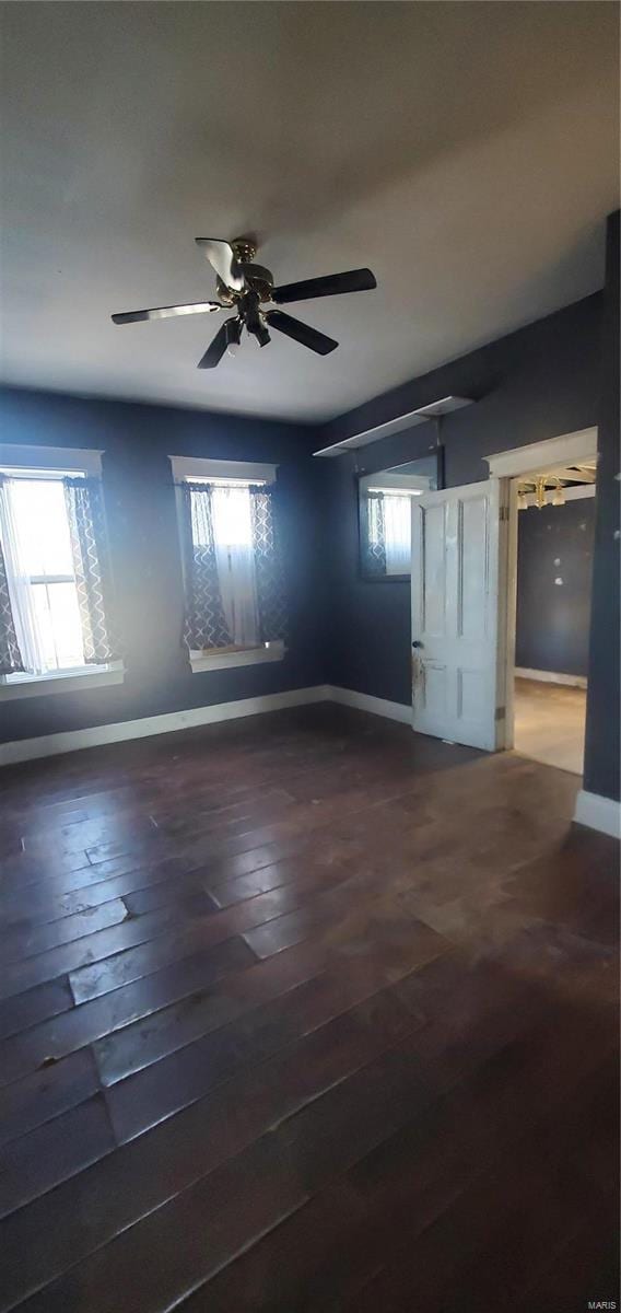 unfurnished room with dark hardwood / wood-style flooring and ceiling fan