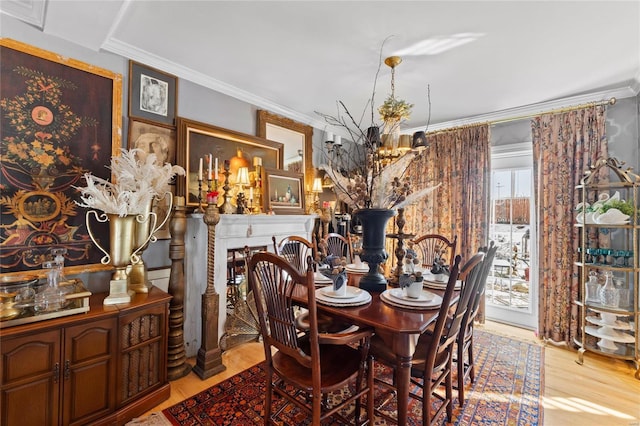 dining area with ornamental molding, a chandelier, and light wood-type flooring