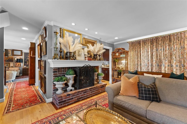 living room featuring ornamental molding, a fireplace, and wood-type flooring