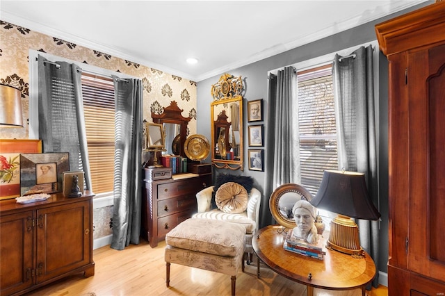 sitting room with ornamental molding and light wood-type flooring