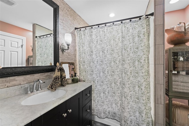 bathroom with vanity, curtained shower, and backsplash