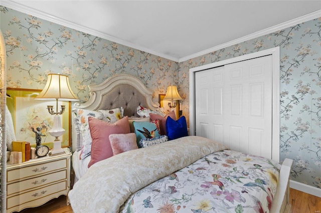 bedroom featuring hardwood / wood-style flooring, ornamental molding, and a closet