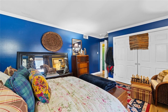 bedroom with crown molding, wood-type flooring, and a closet