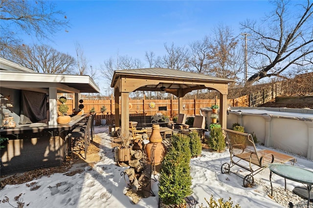 snow covered patio with a bar, a gazebo, and a covered pool