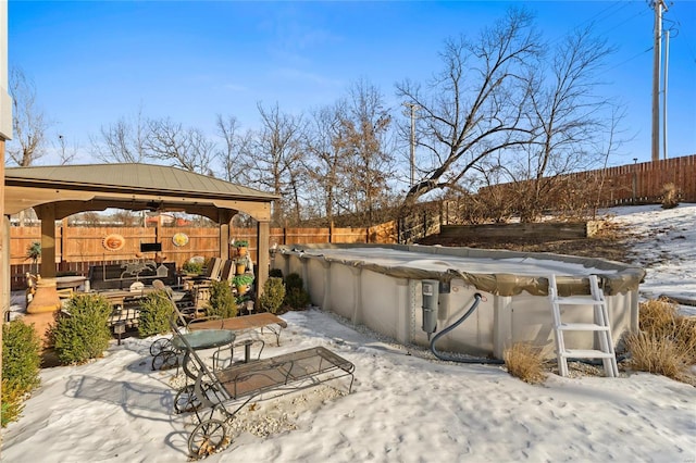 snow covered patio with a gazebo and a covered pool