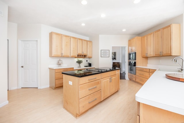 kitchen with light brown cabinetry, sink, a kitchen island, and black microwave