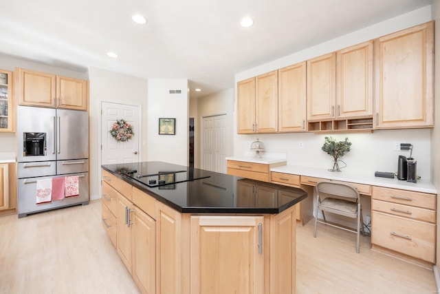 kitchen with a center island, high end fridge, light brown cabinetry, and light hardwood / wood-style floors