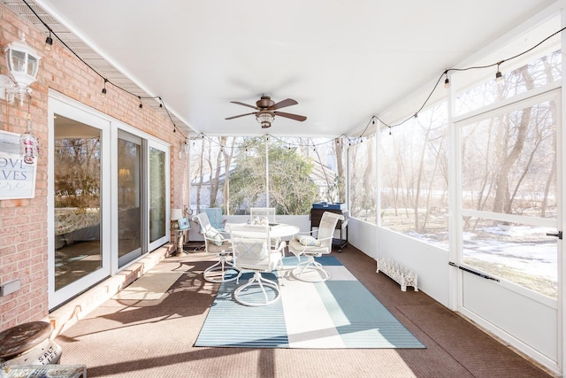 sunroom featuring ceiling fan and radiator