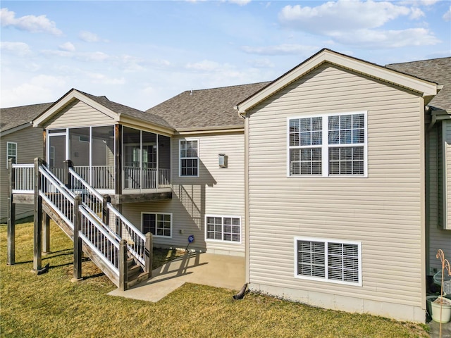 back of house featuring a sunroom, a lawn, and a patio area