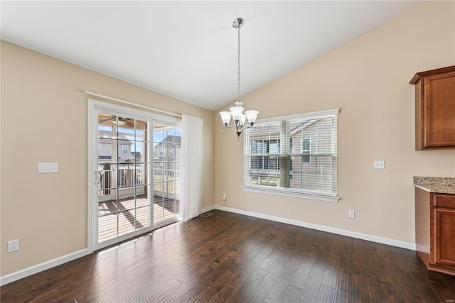 unfurnished dining area with dark hardwood / wood-style flooring, a notable chandelier, and vaulted ceiling