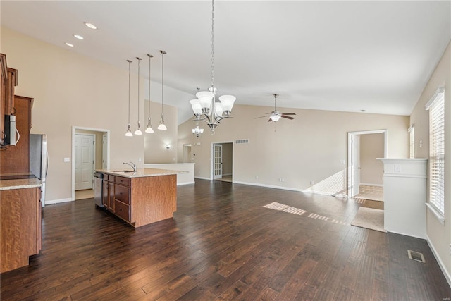 kitchen with sink, appliances with stainless steel finishes, dark hardwood / wood-style floors, an island with sink, and pendant lighting