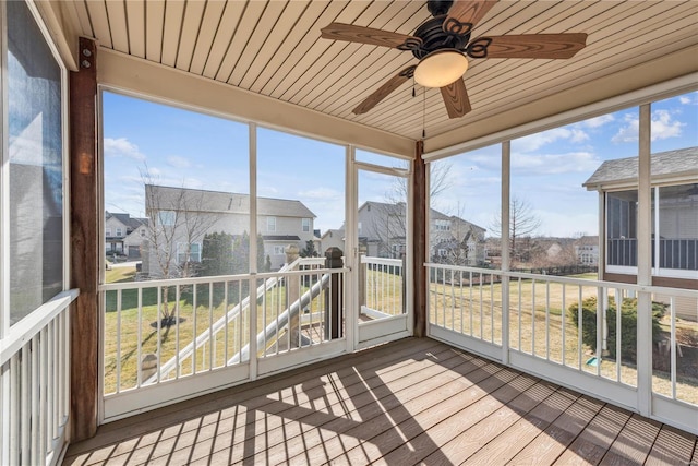 unfurnished sunroom featuring plenty of natural light, wooden ceiling, and ceiling fan