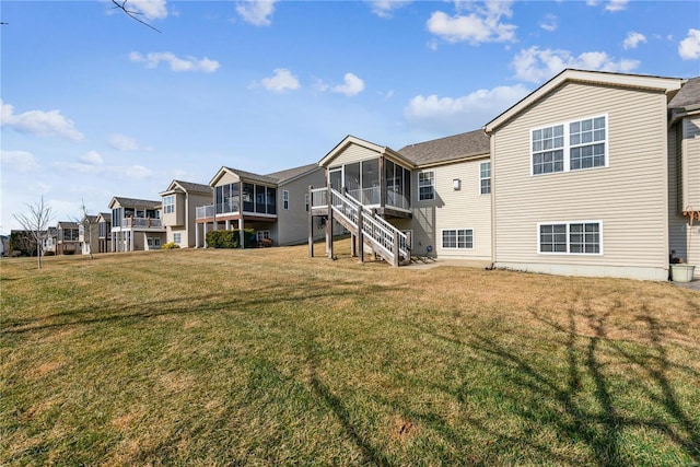 rear view of property with a sunroom and a yard