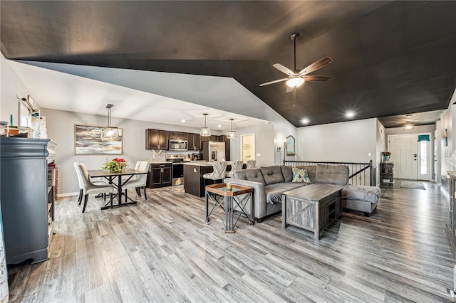 living room featuring vaulted ceiling, ceiling fan, and hardwood / wood-style floors