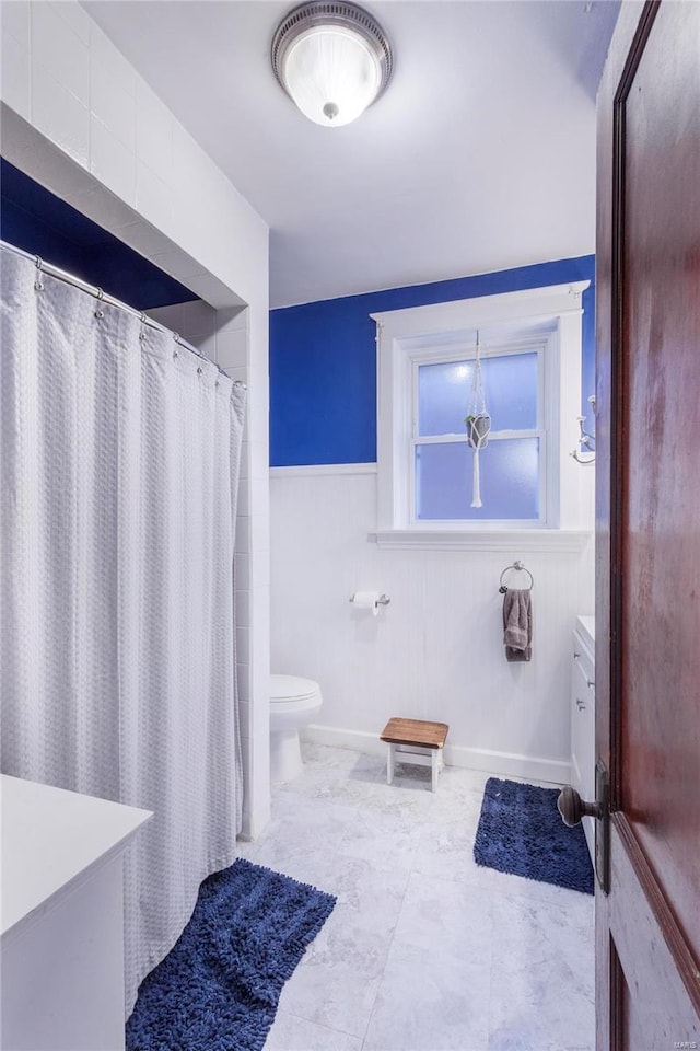 bathroom featuring walk in shower, vanity, and toilet