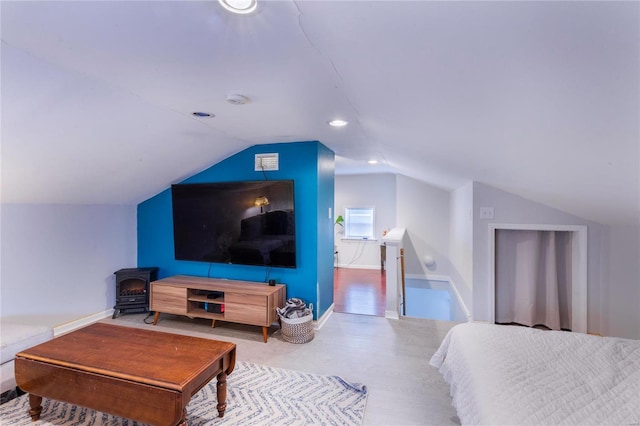 bedroom featuring lofted ceiling and a wood stove